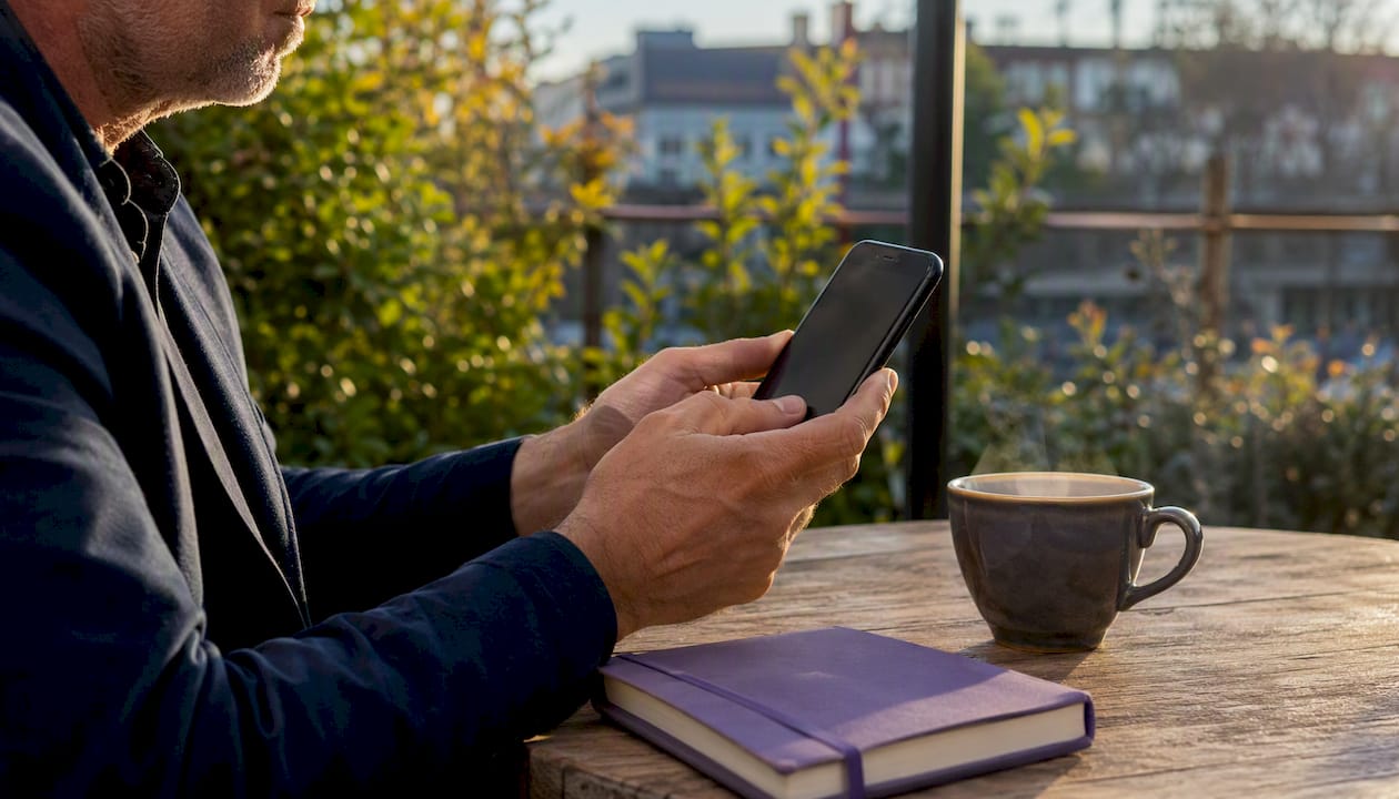 Hands sending follow-up email on phone