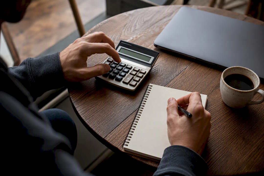 Hands calculating startup equity percentages