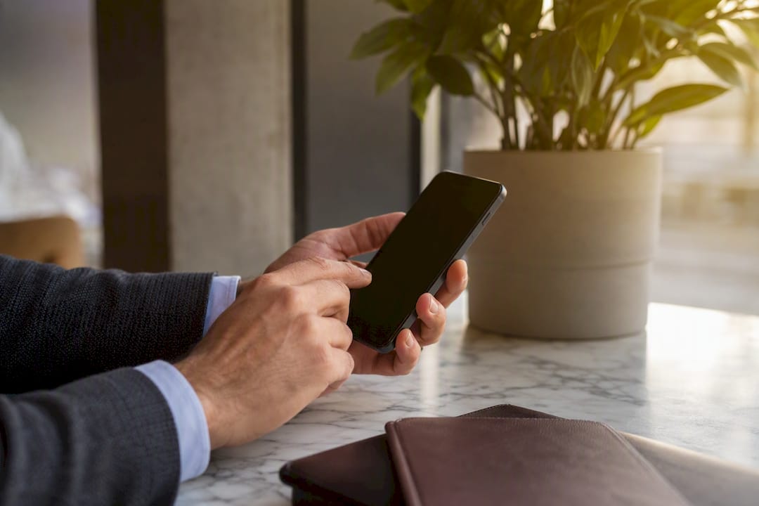 Hands scheduling LinkedIn posts on smartphone